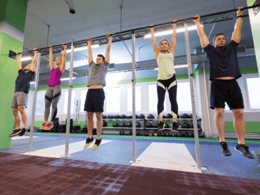 people hanging from a bar