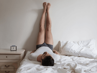 Picture of a man doing yoga in bed