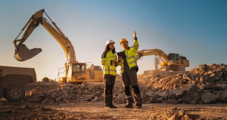 Bulldozer operating behind woman and man in construction vests