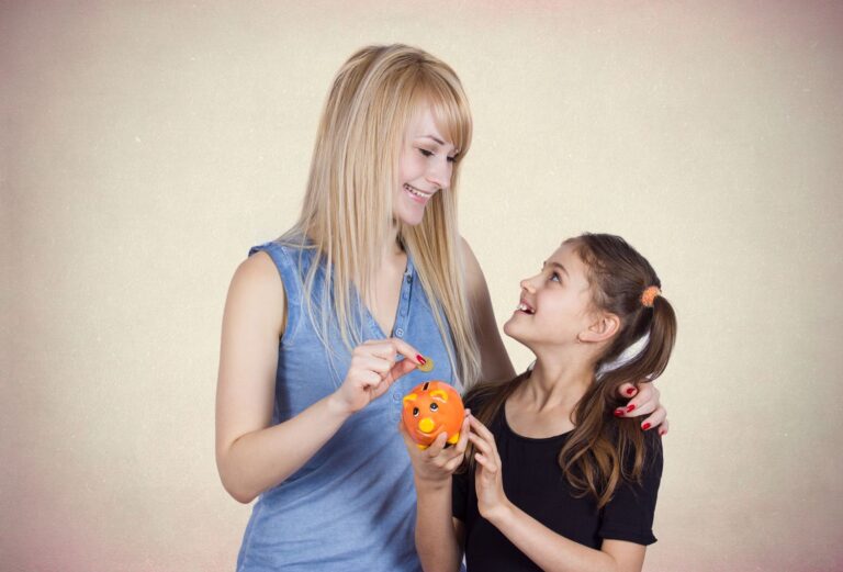 Woman and young girl holding a piggy bank