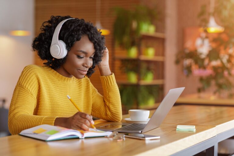 Woman with headphones on studying at a computer