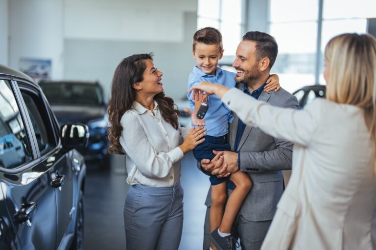 Woman, man and small child receiving keys from another woman in a blazer