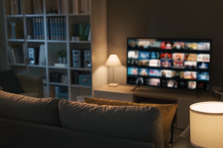 Couch in front of tv with multiple streaming service icons on it