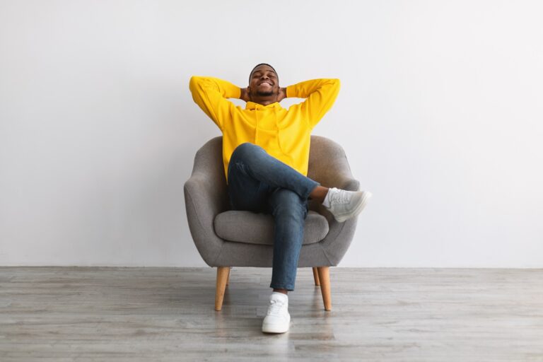 Man in yellow sweatshirt reclining in a chair